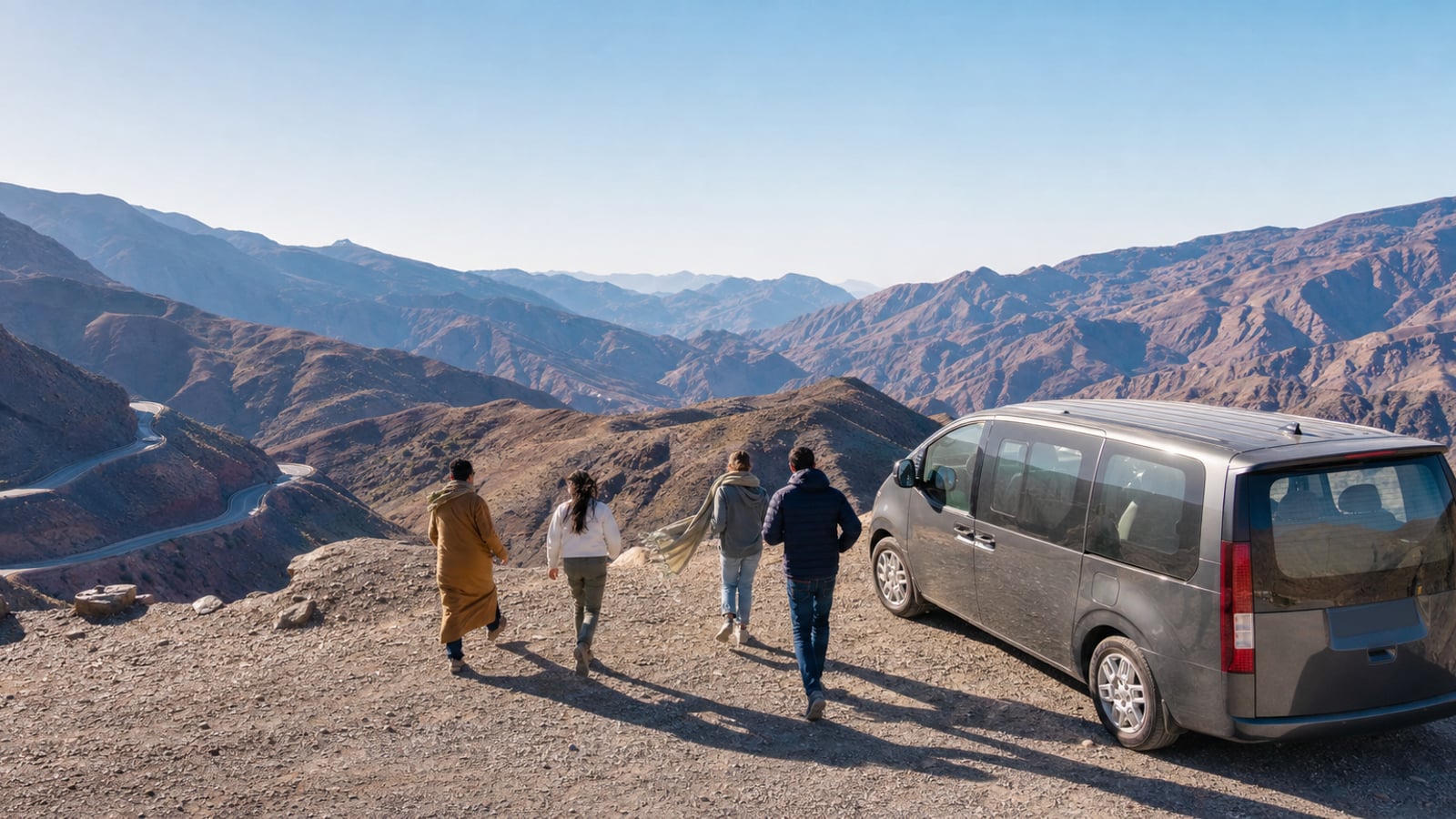 Travellers stopping with their guide above the winding Tizi n'Tichka road